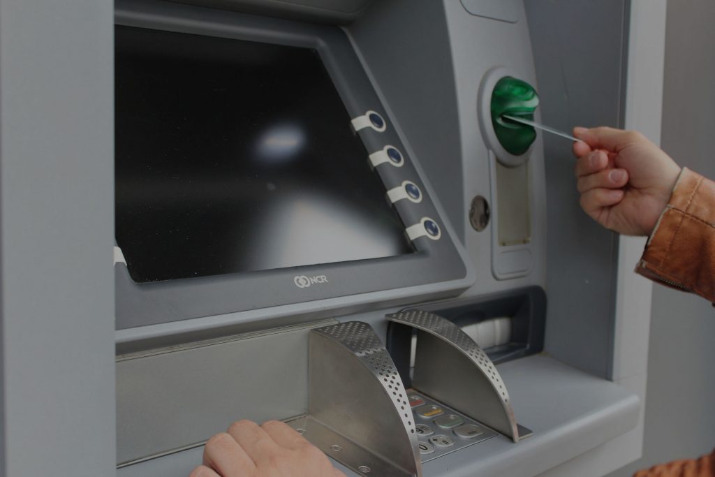 a man putting a card into an ATM machine
