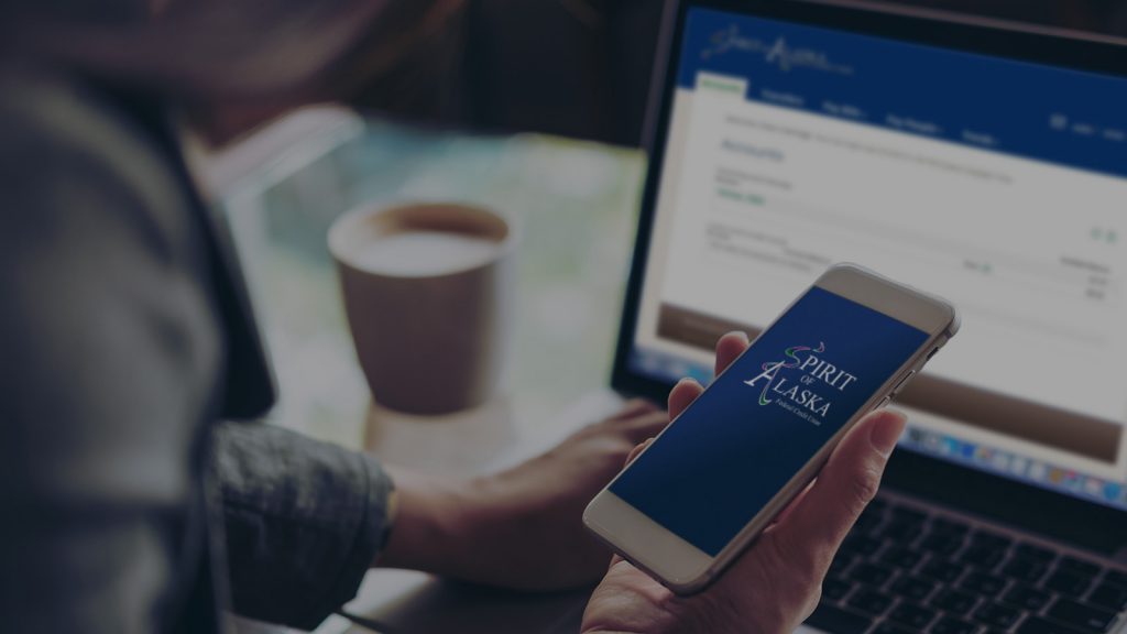 mockup image of person holding phone in front of computer